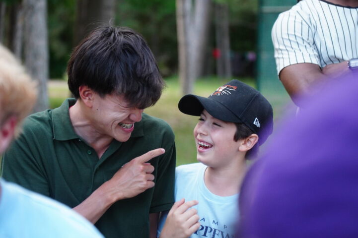 counselor and camper smiling at each other.