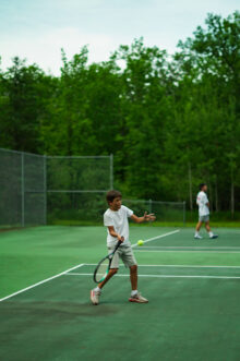 boy returning a tennis volley.