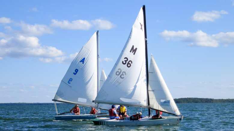 two sailboats on a calm lake.