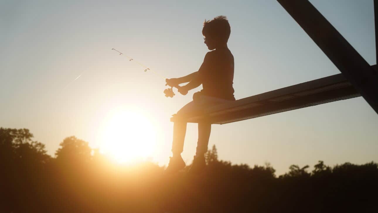 camper fishing during sunset
