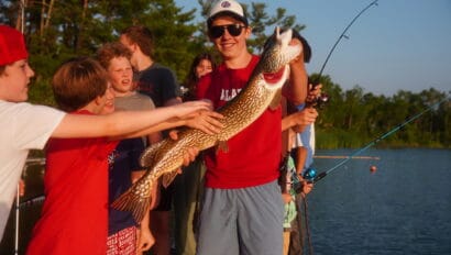 a camper holding a northern pike