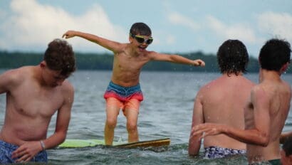 a camper playing on a water mat in the lake