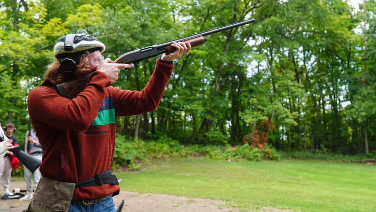 boy shooting trap at summer camp.
