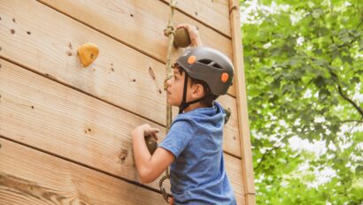 boy in helmet on climbing wall.