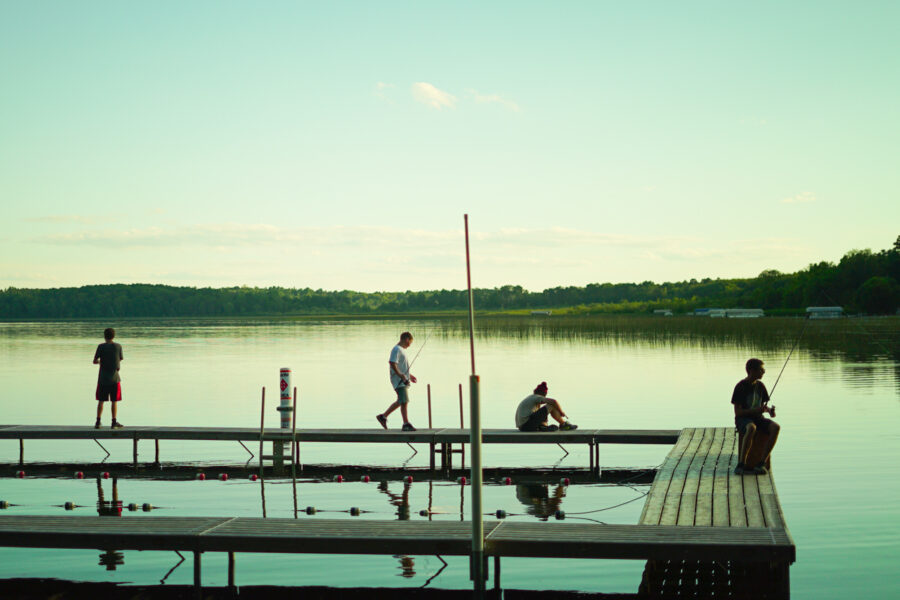 boys on a dock on a lake.