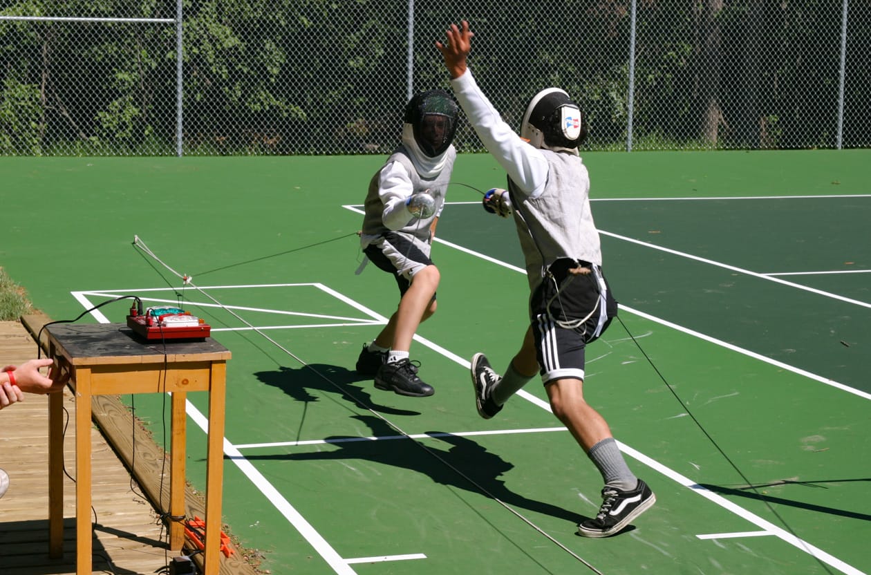boys fencing on tennis court.