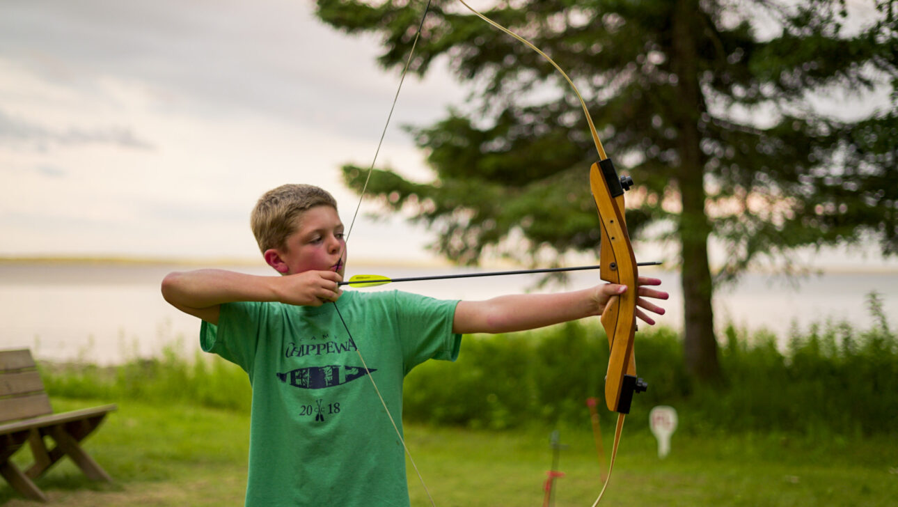 boy pulling back bow.