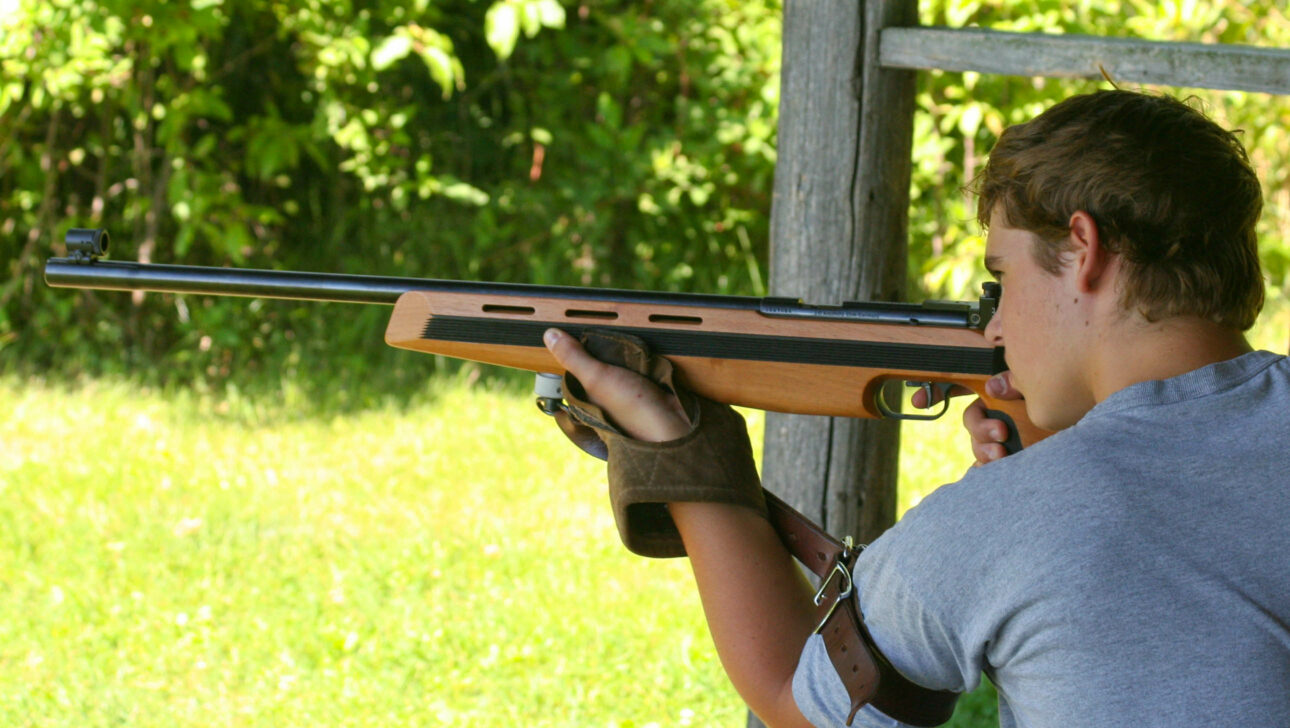 boy shooting rifle with wrist support.