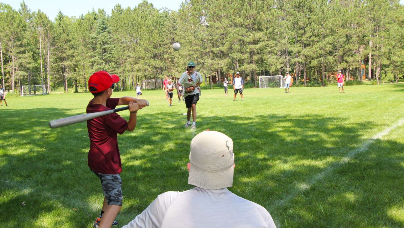 umpires view of a softball game involving a group of boys.