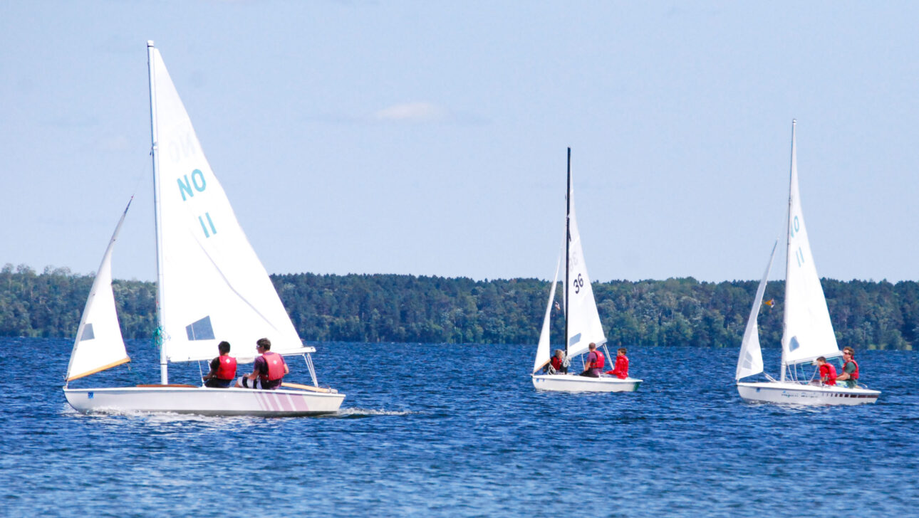 three sailboats on the water.