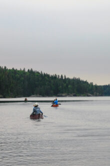 canoes rowing away on a lake.