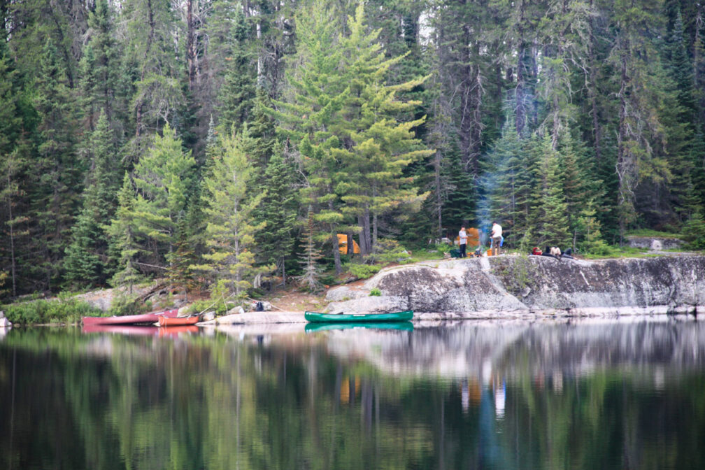 canoes on a river bank at a campsite.