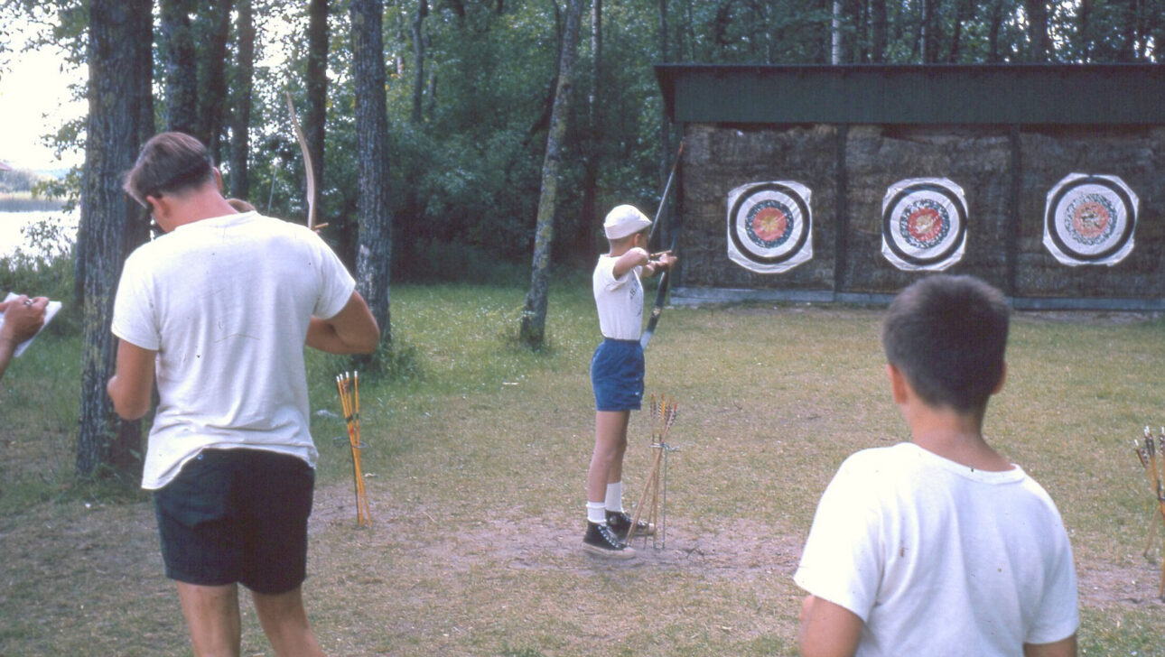 A vintage image of boys playing archery.