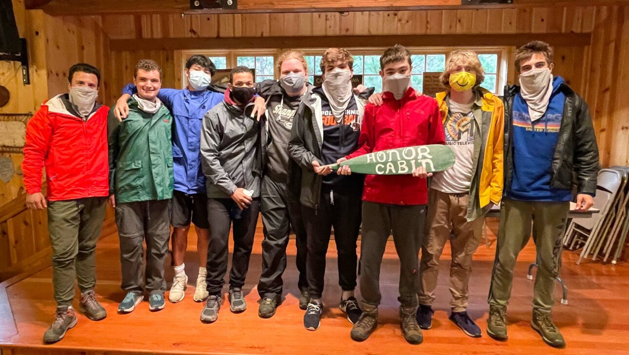 group of boys holding honor cabin sign indoors.