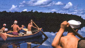 boys on two canoes on a lake.