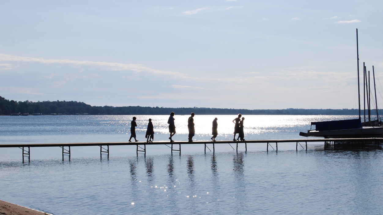 boys walking across a dock i the distance