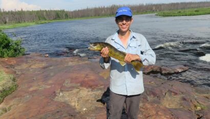 camper holding a large walleye in Canada.