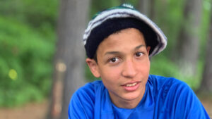 boy wearing a tam and smiling.