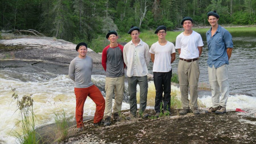 a group wearing tams standing by rapids.