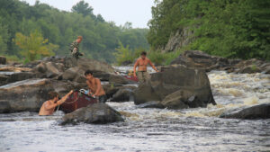 group lining canoes through rapids.