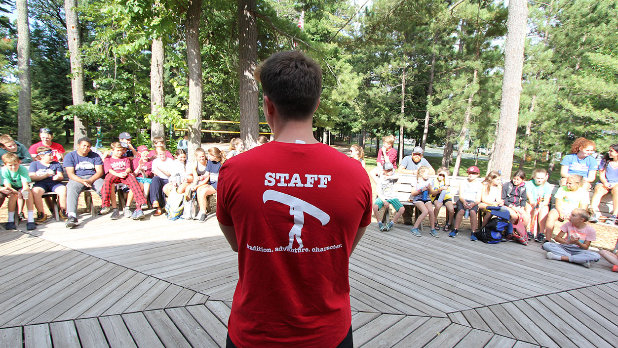 counselor showing off the back of his staff shirt.