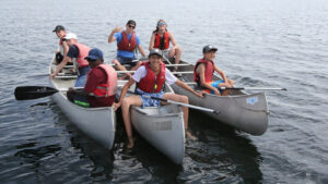 canoes floating together in a lake.