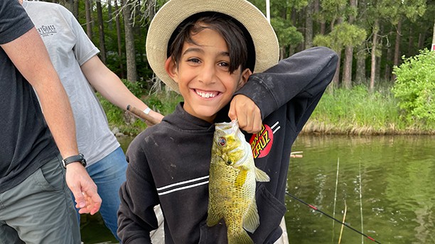 boy feeling proud and holding a fish he just caught