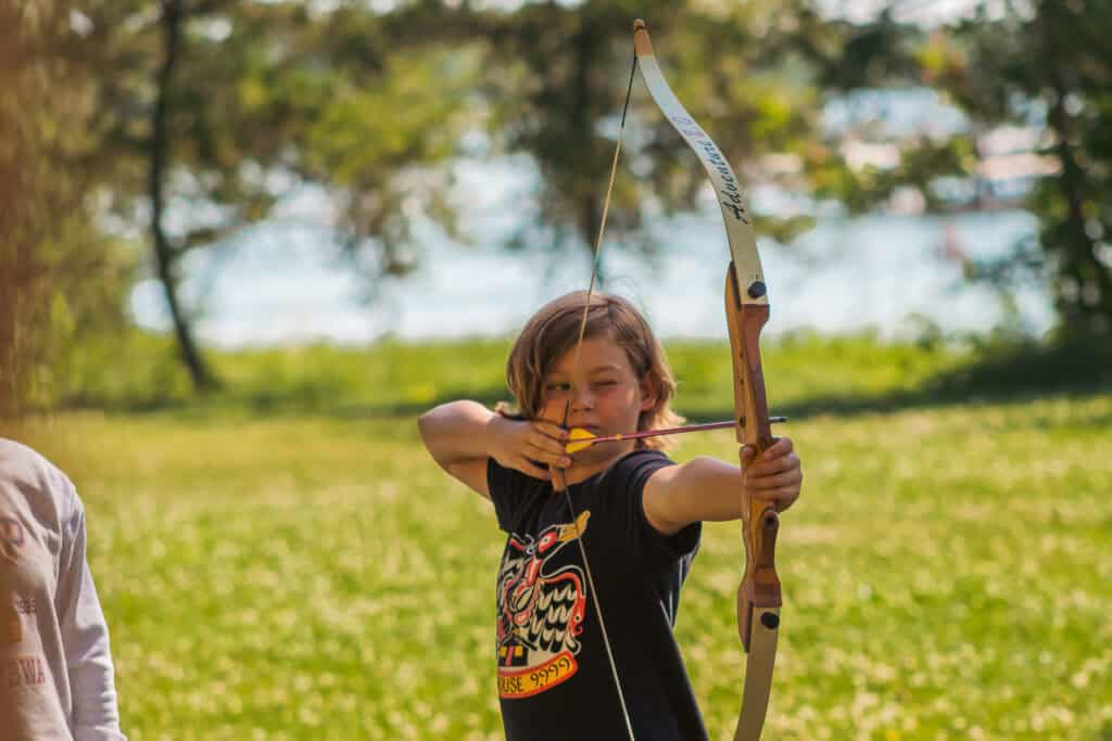 Young camper shooting archery at a Minnesota summer camp.