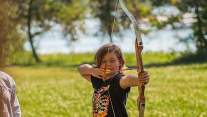 Camper with good archery form getting ready to release his arrow at Camp Chippewa.