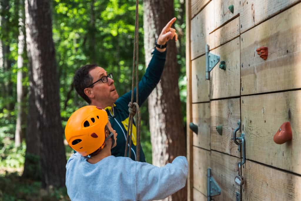 Counselor teaching climbing to camper at summer camp in Minnesota, Camp Chippewa for Boys