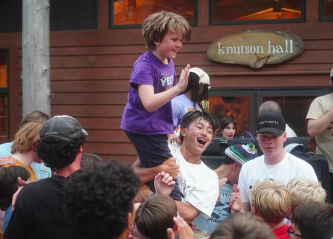 a counselor celebrates a young campers achievement.