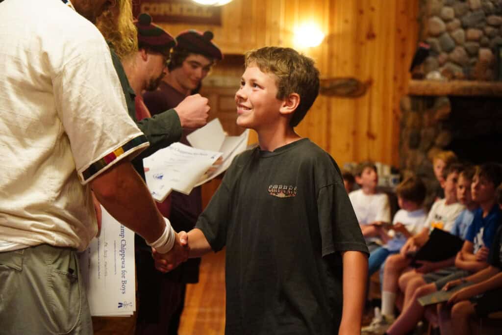 a camper is recognized by staff for his accomplishments
