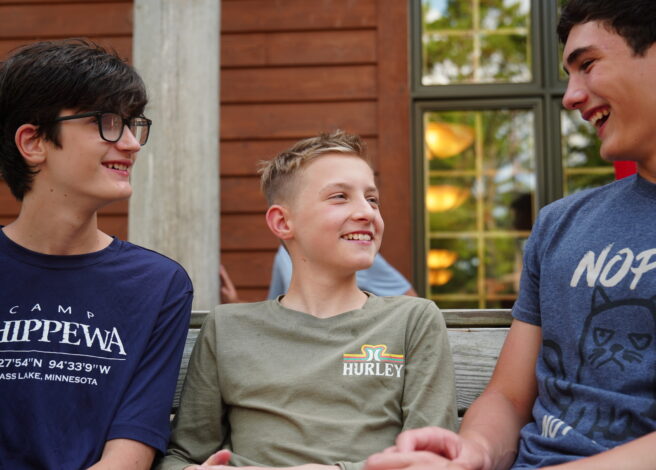 three campers smiling and talking.