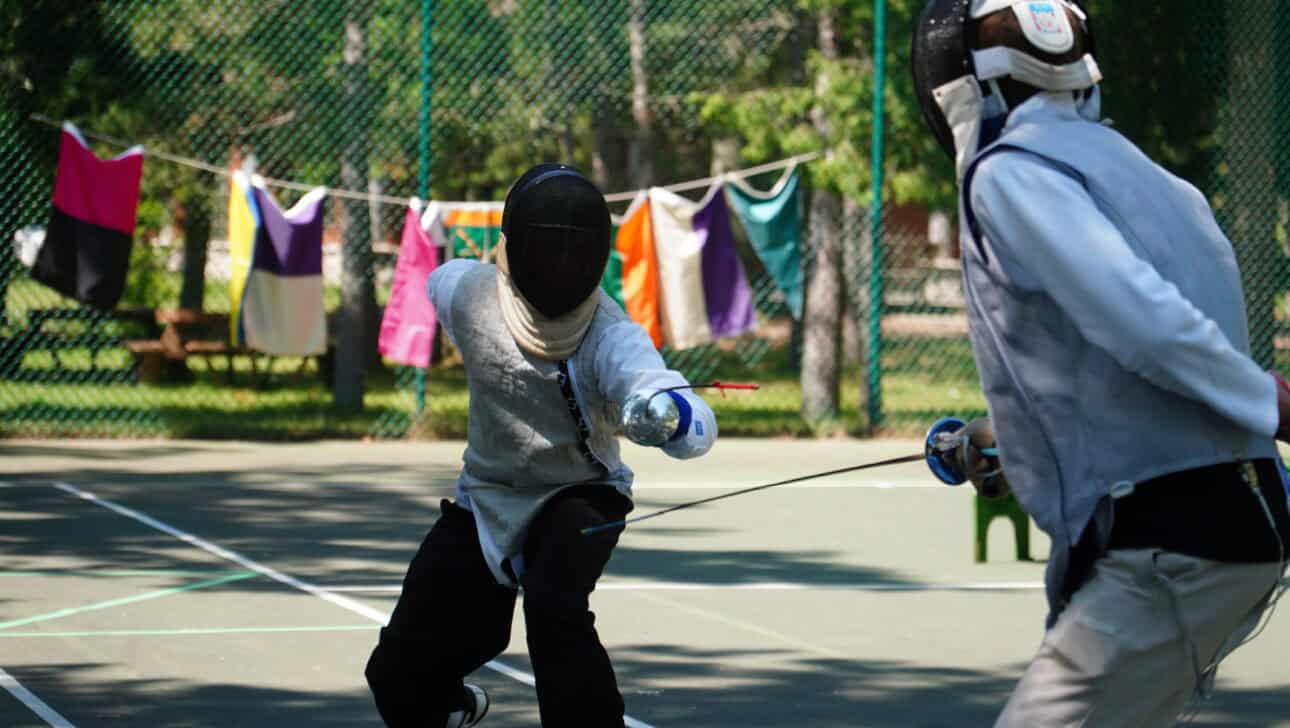 two boys with masks fencing.