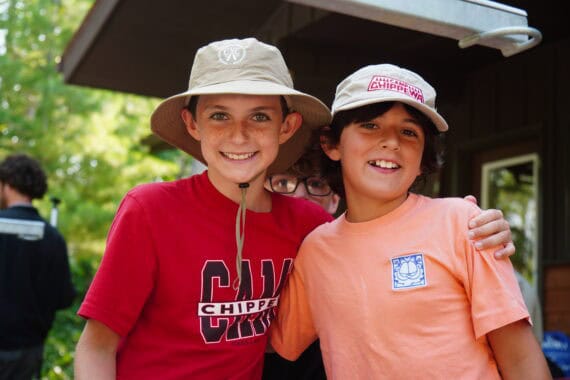 two boys with hats smiling at summer camp.