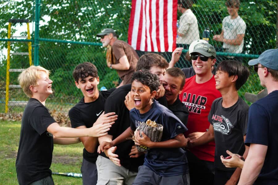 group of boys smiling after winning a baseball game.